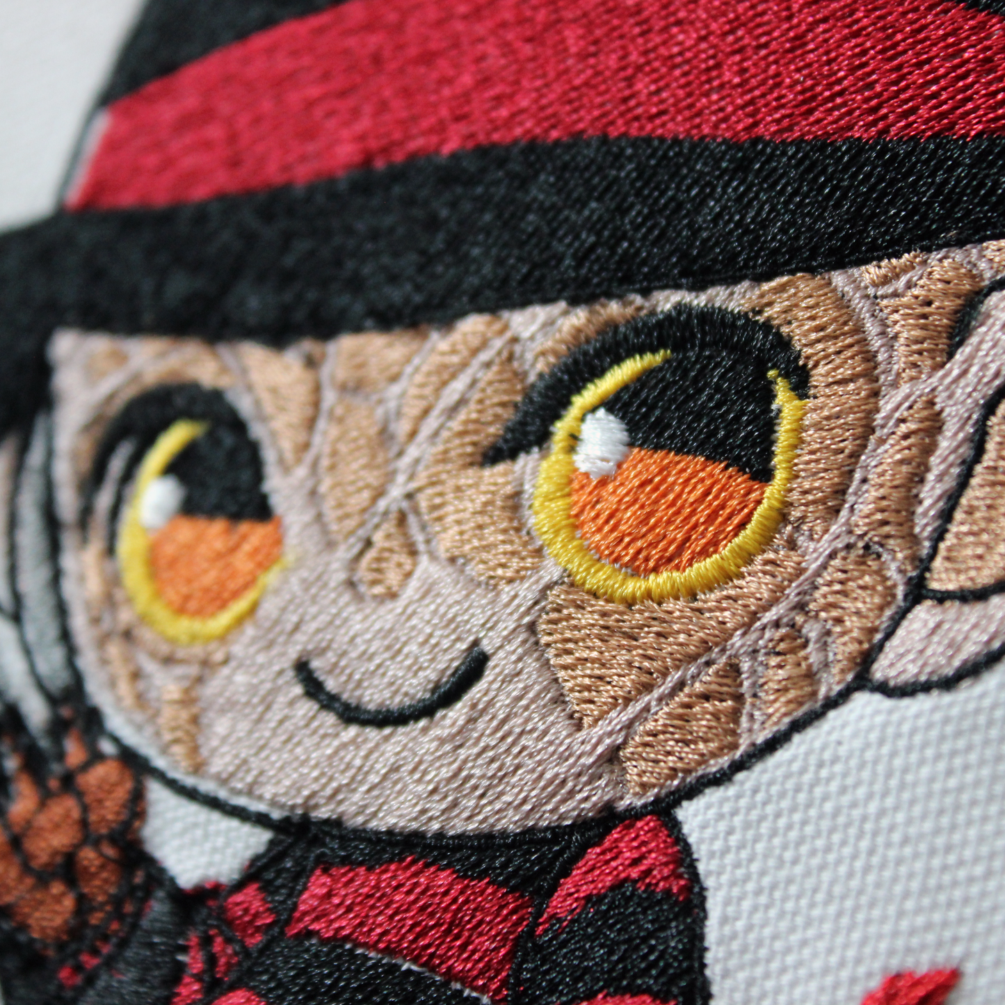 Embroidery of Freddy Krueger with a hat and flames in an embroidery hoop.
