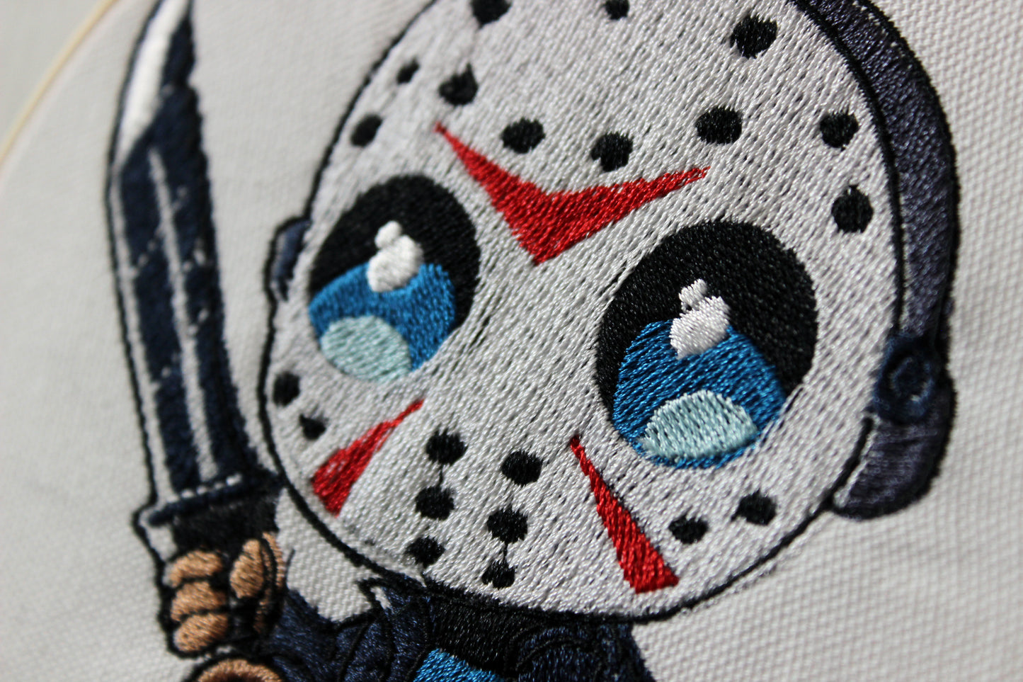 Embroidered patch of Jason with a mask and knife on a white background.