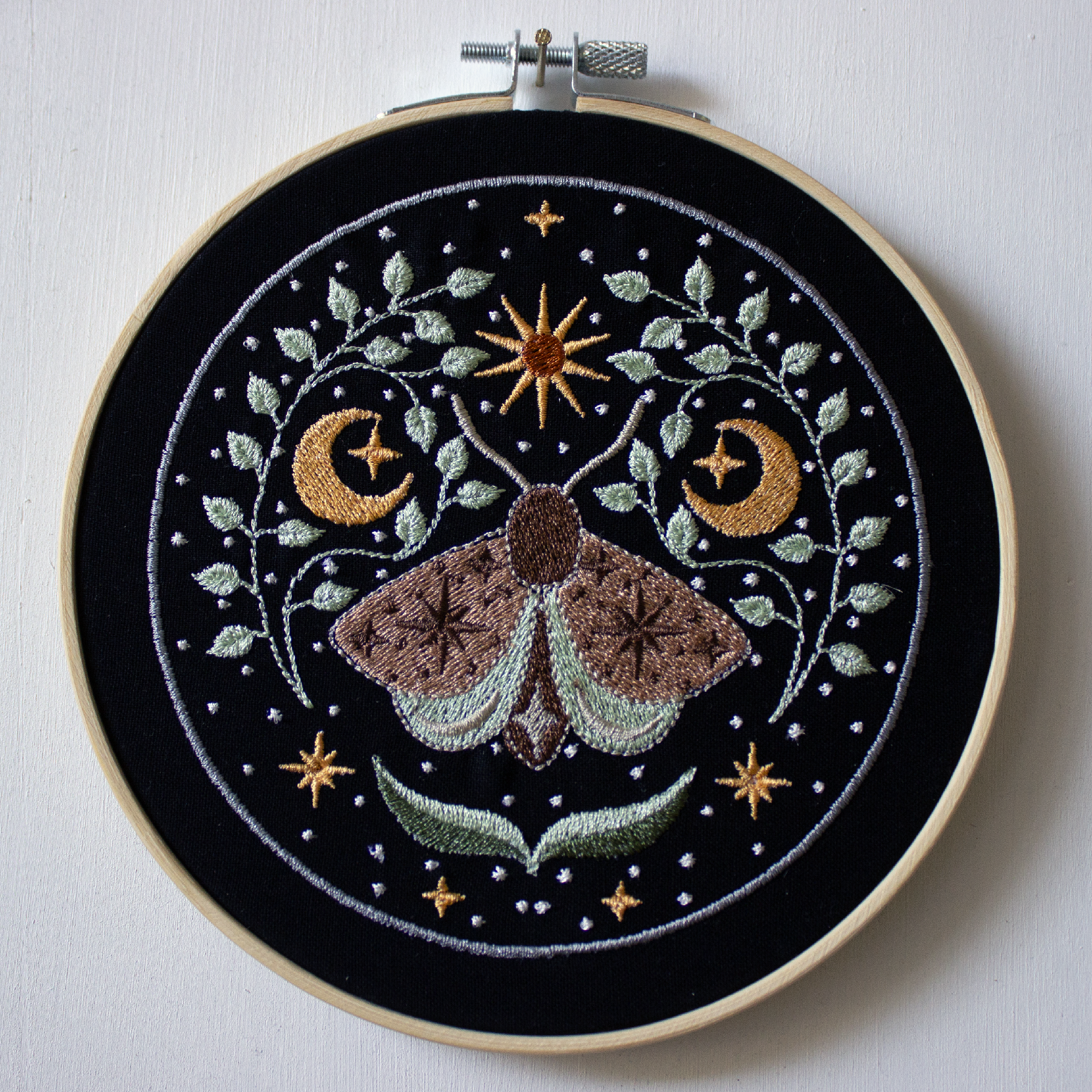Moth with the moon and stars on a black background.