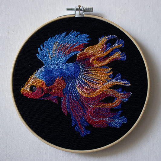 Colorful embroidered fish on a black background.