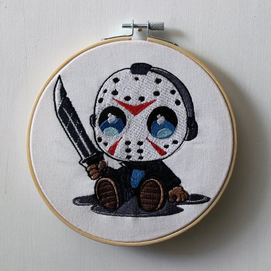 Embroidery hoop with a Jason holding a knife on a white background.