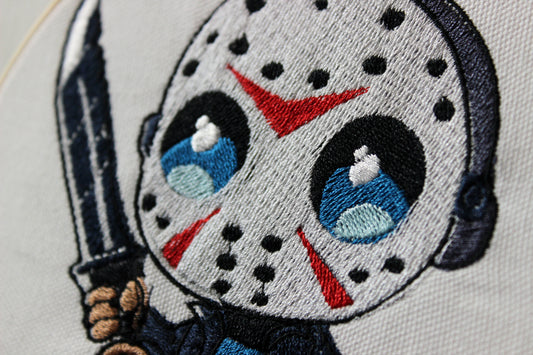 Embroidered patch of Jason with a mask and knife on a white background.