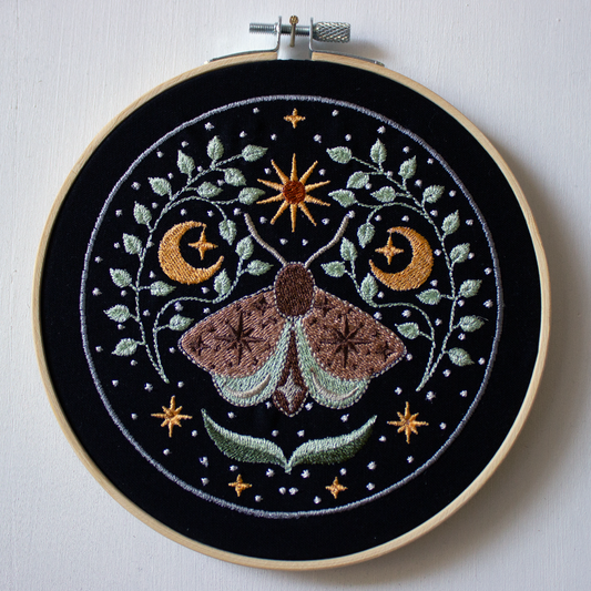 Moth with the moon and stars on a black background.
